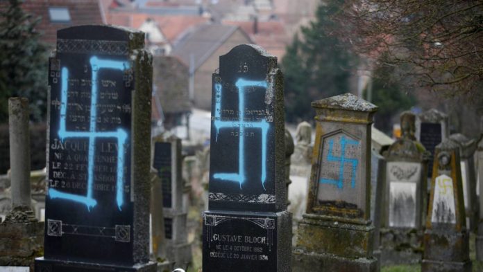 Graves desecrated with swastikas are seen in the Jewish cemetery in Quatzenheim